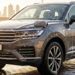 A dark SUV undergoing a rich foam wash in a sunny Dubai driveway.
