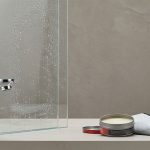 An open car wax tin and microfiber cloth next to a shiny chrome faucet.