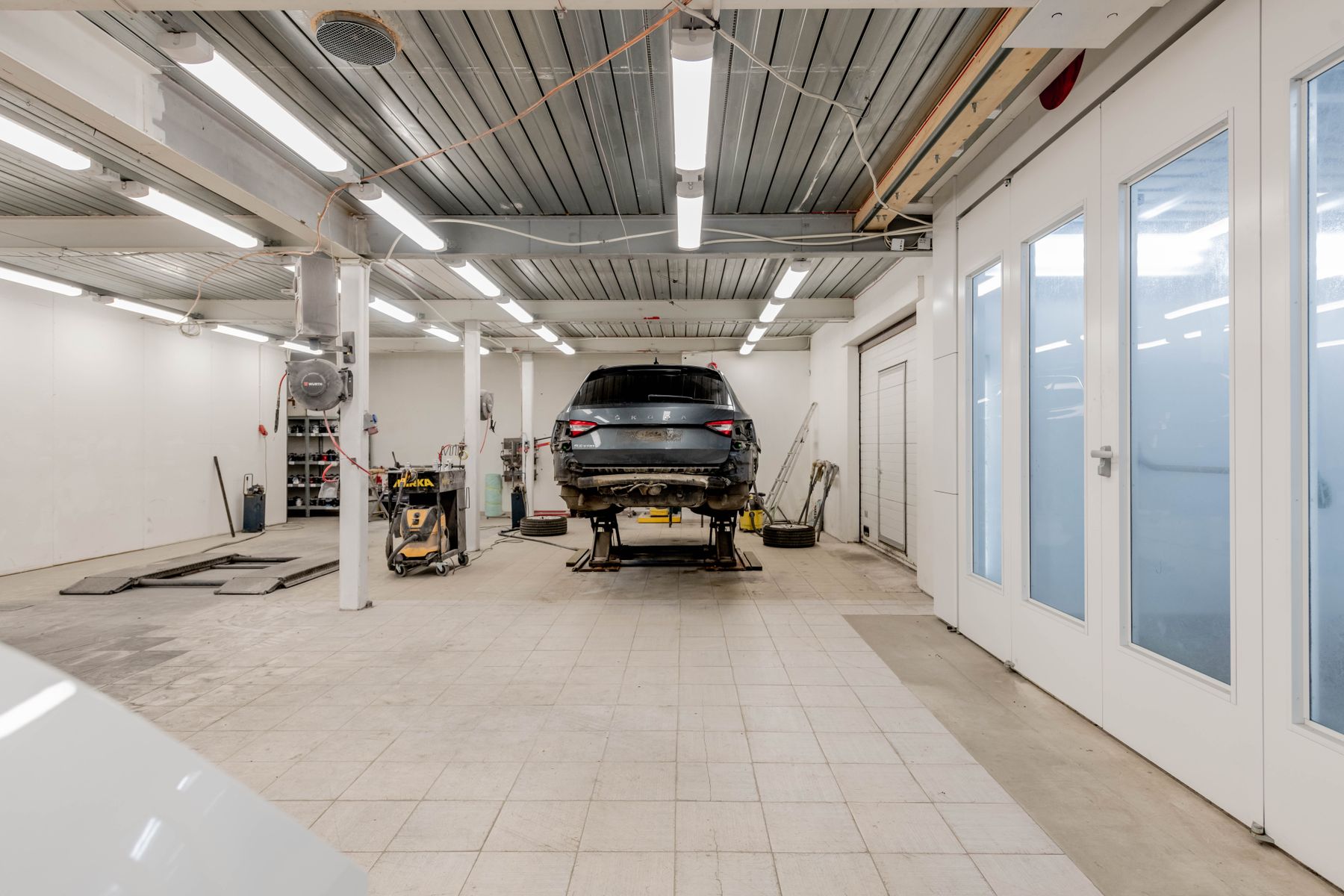 Car on a hydraulic lift in a well lit workshop