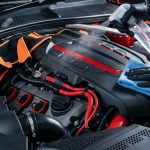 Clean car engine with a cloth, spray bottle, and covered wiring.