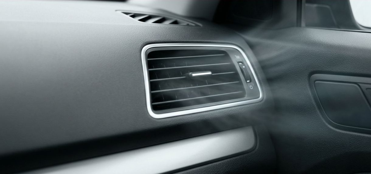 Car dashboard air vent with faint musty haze and a red Fresh Air banner.